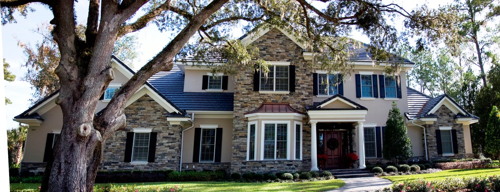 Example of a mid-sized classic beige two-story stone exterior home design in Orlando