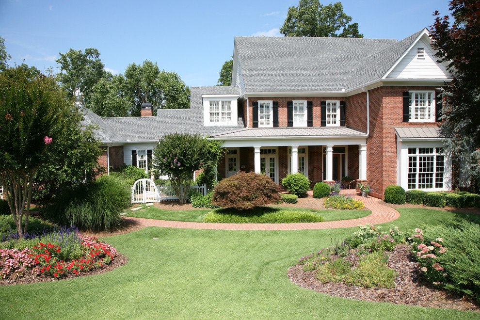 Design ideas for a traditional brick house exterior in Atlanta with three floors.