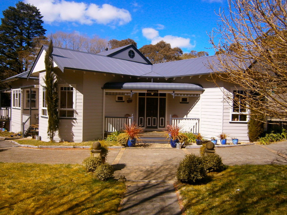 Exemple d'une grande façade de maison beige chic de plain-pied avec un toit à deux pans.