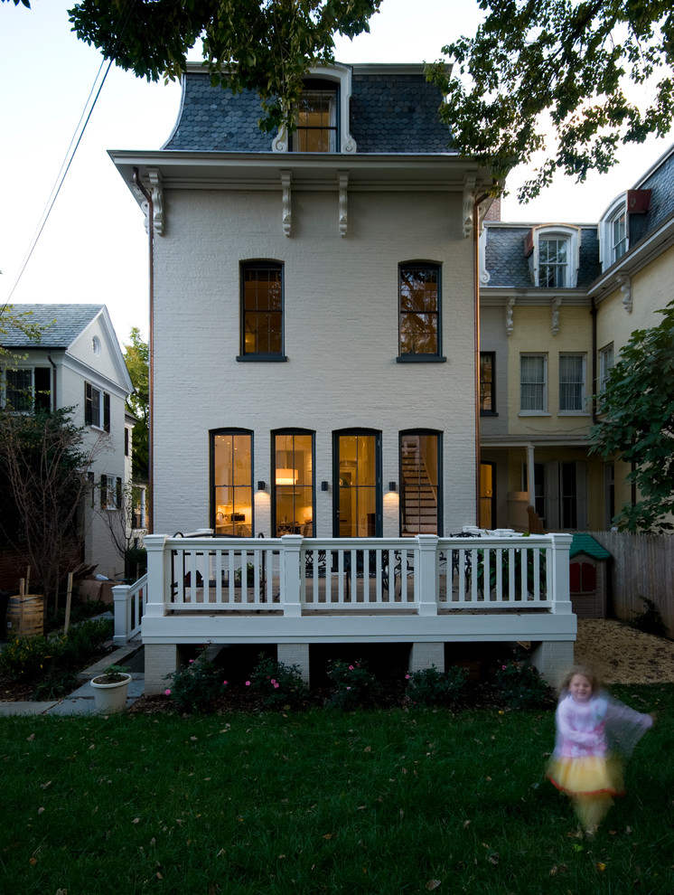 Immagine della facciata di una casa bianca classica a tre piani con rivestimento in mattoni
