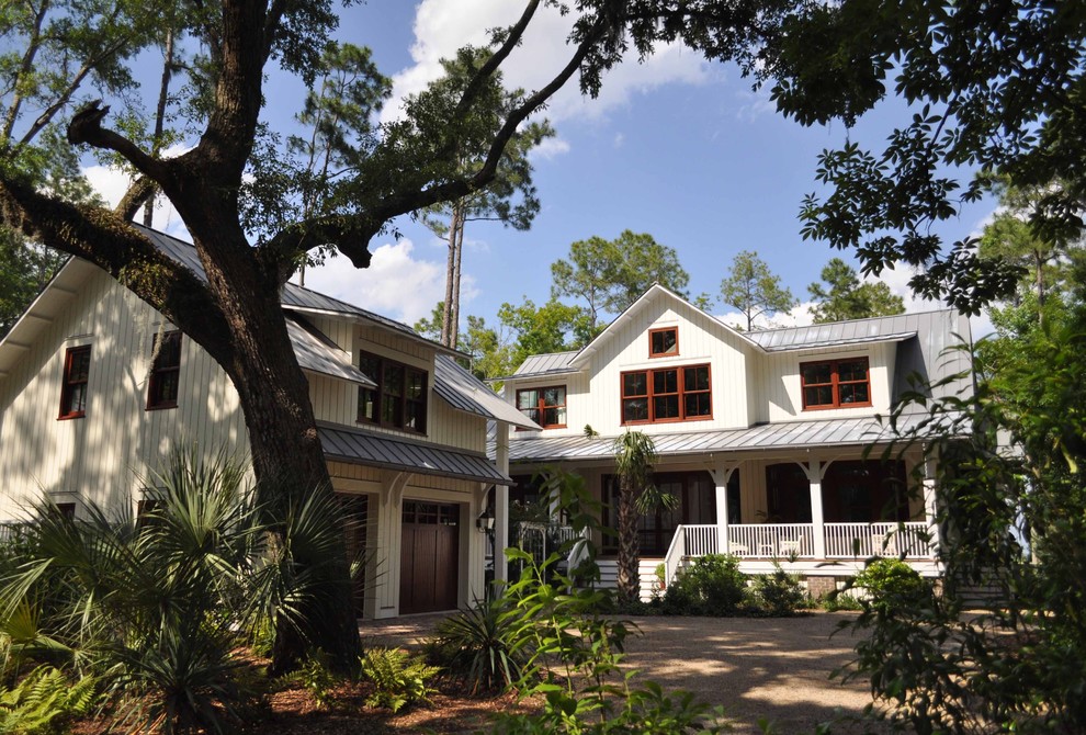 This is an example of a large and white classic two floor house exterior in Charleston with wood cladding.
