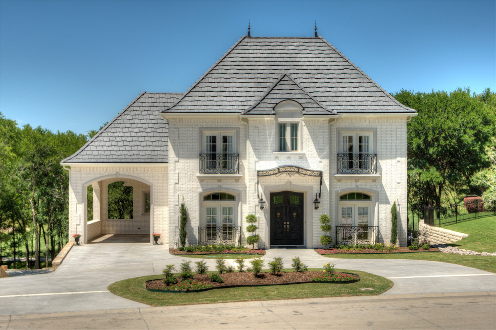 Idee per la facciata di una casa bianca classica a due piani con rivestimento in mattoni e tetto a padiglione