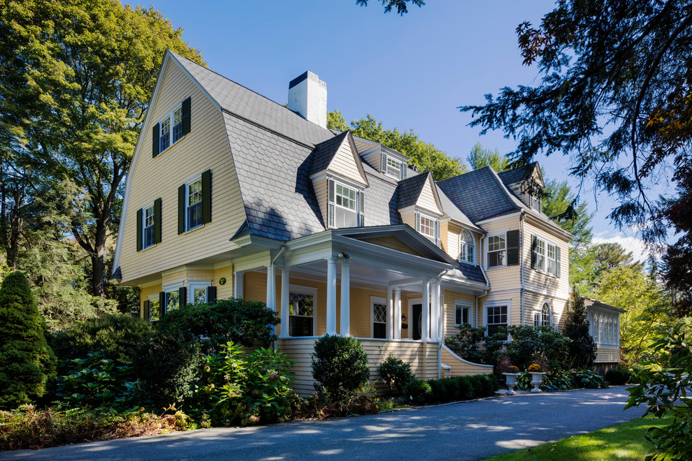 Dreistöckiges Klassisches Haus mit gelber Fassadenfarbe, Mansardendach und Schindeldach in Boston