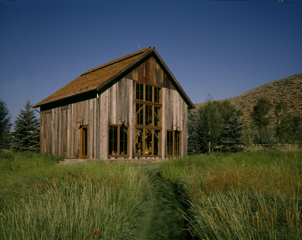 Cette image montre une façade de grange rénovée chalet en bois.