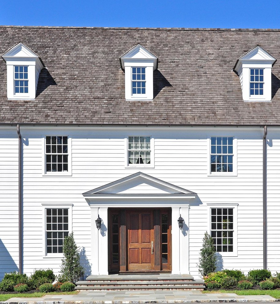 Réalisation d'une grande façade de maison blanche tradition en bois à deux étages et plus avec un toit à deux pans.