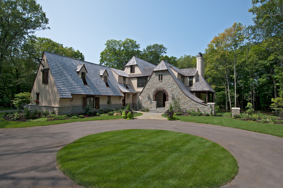 Пример оригинального дизайна: дом в классическом стиле с облицовкой из камня и полувальмовой крышей