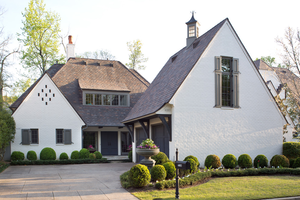 Diseño de fachada blanca tradicional de dos plantas con revestimiento de ladrillo y tejado a dos aguas