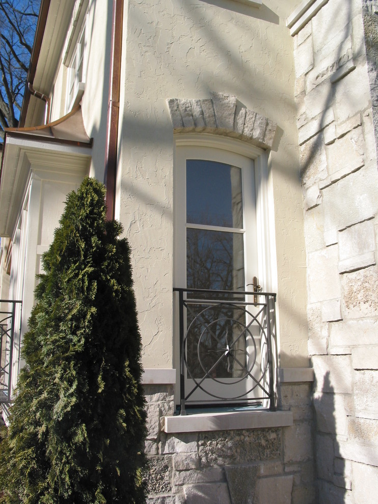 Exemple d'une façade de maison beige chic en stuc à un étage.