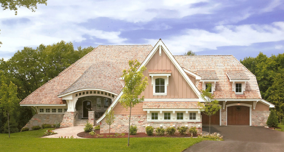 Esempio della facciata di una casa beige classica a due piani con rivestimenti misti