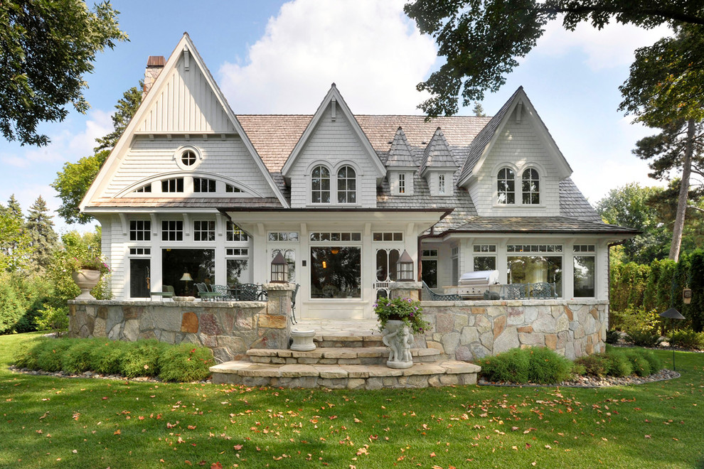 Cette photo montre une façade de maison blanche chic avec un toit à deux pans.