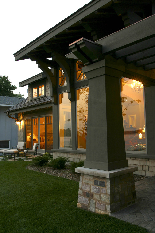 Cette image montre une grande façade de maison verte traditionnelle en bois à un étage avec un toit à deux pans et un toit en shingle.