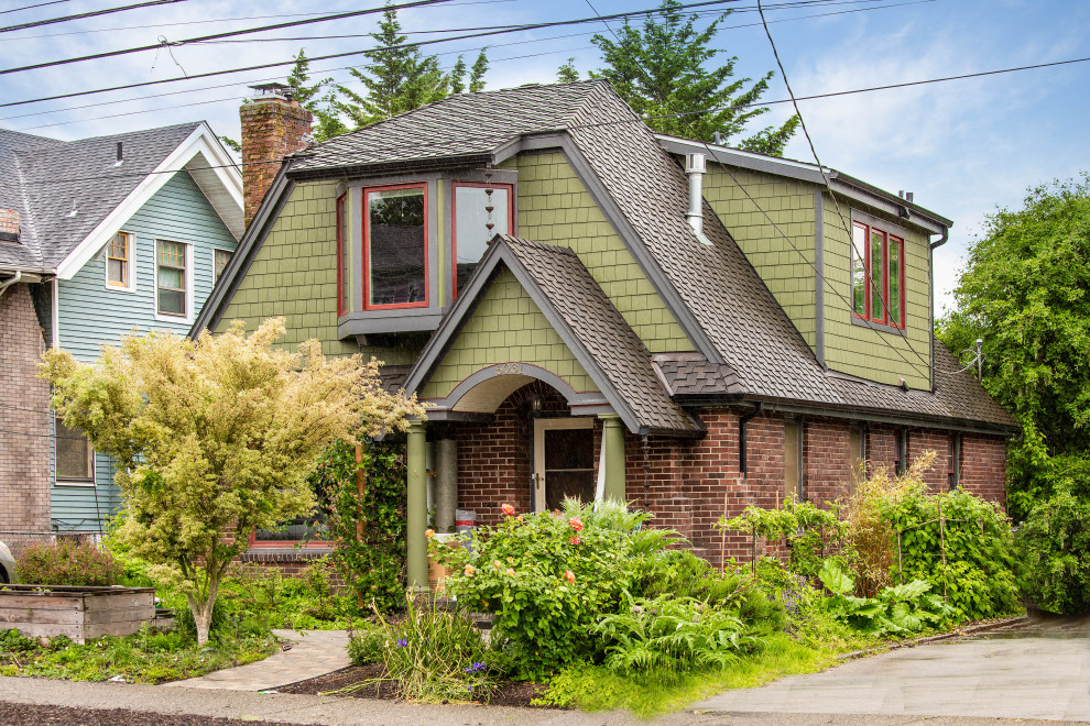 Exemple d'une façade de maison verte chic en bardeaux à un étage avec un toit en shingle et un toit marron.