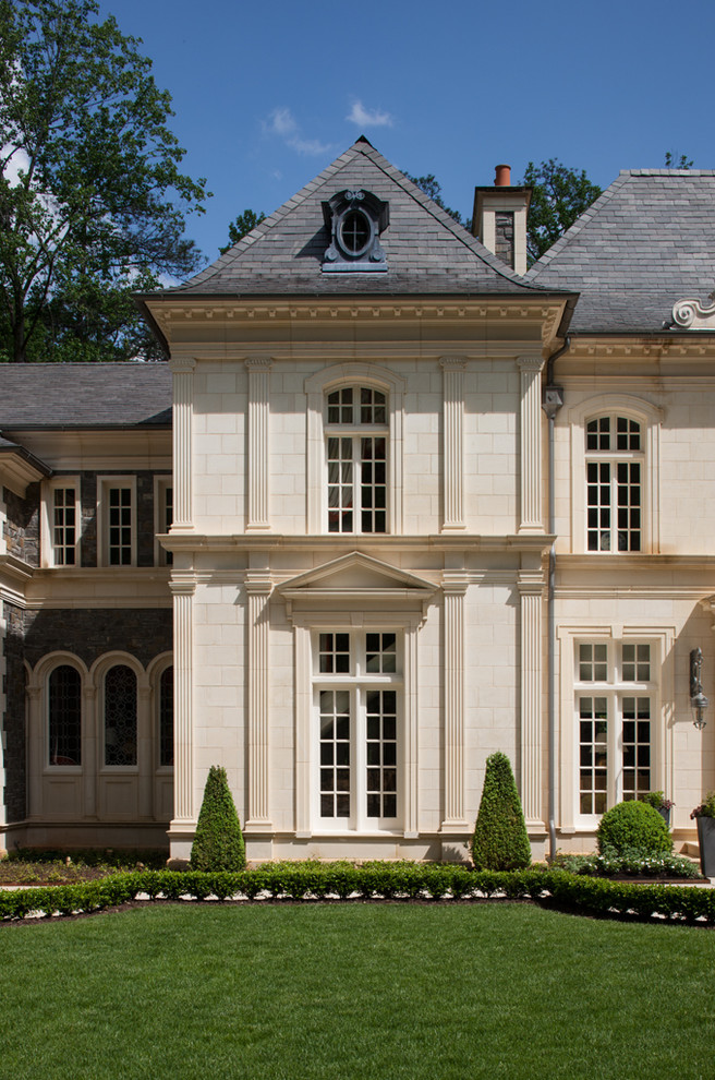 Inspiration pour une très grande façade de maison beige traditionnelle en pierre à un étage avec un toit à quatre pans.