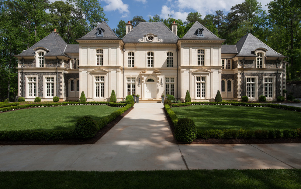 Huge french country beige two-story stone exterior home photo in Atlanta with a hip roof