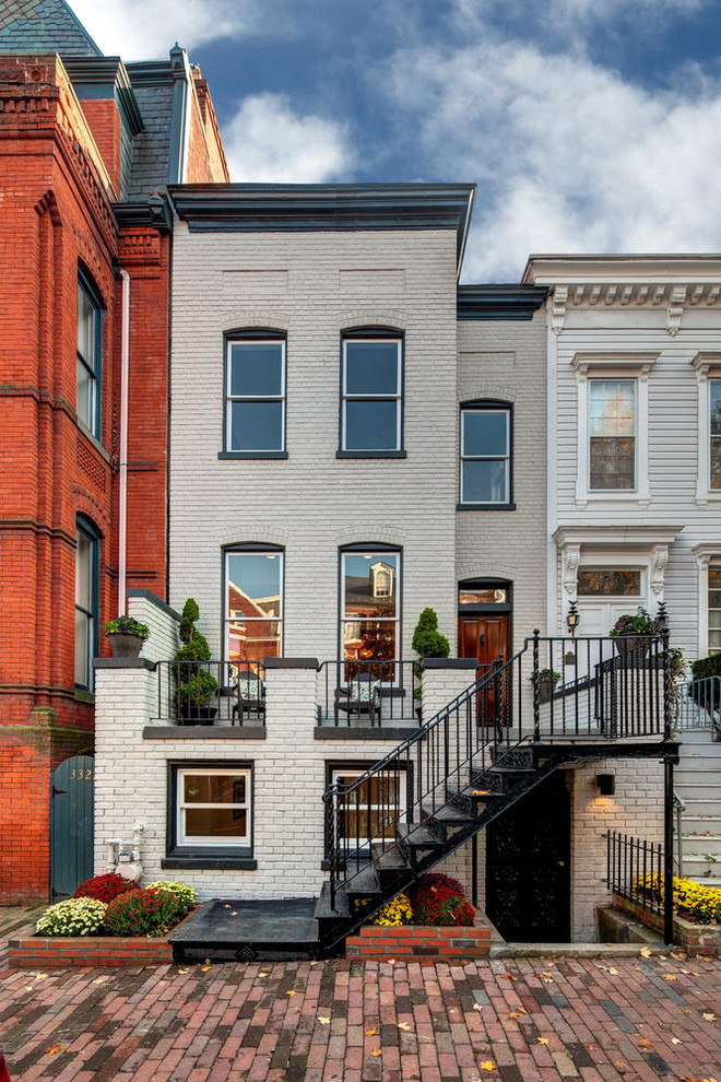 This is an example of a beige classic brick terraced house in DC Metro with three floors.