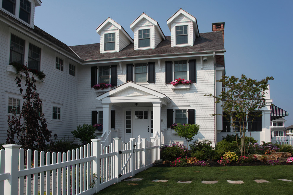 Photo of a white coastal house exterior in Philadelphia with three floors and wood cladding.