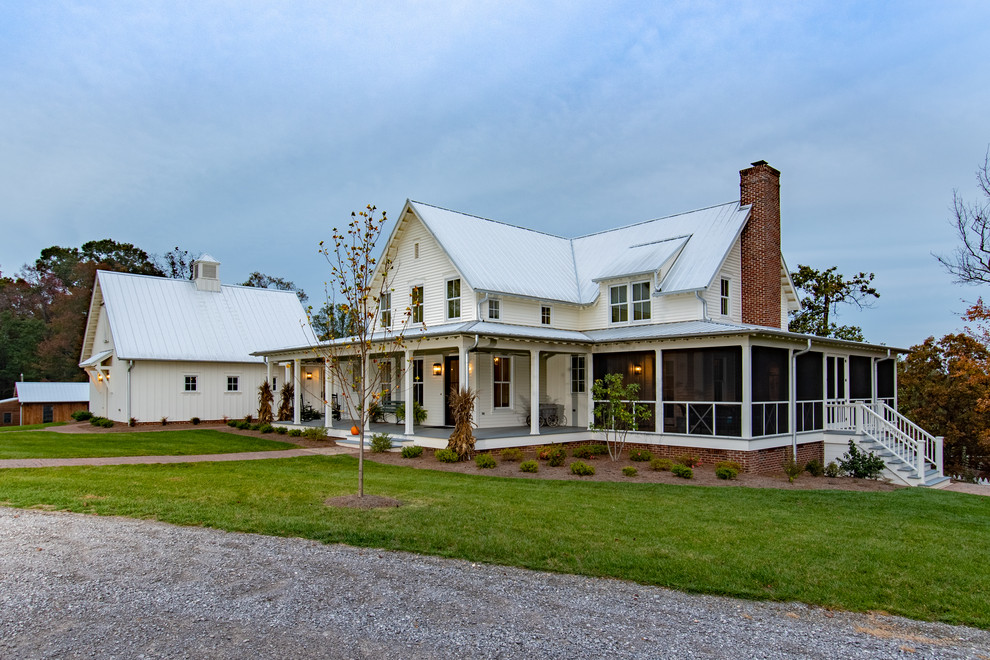 Cette photo montre une grande façade de maison blanche nature en panneau de béton fibré à deux étages et plus avec un toit en métal et un toit à deux pans.