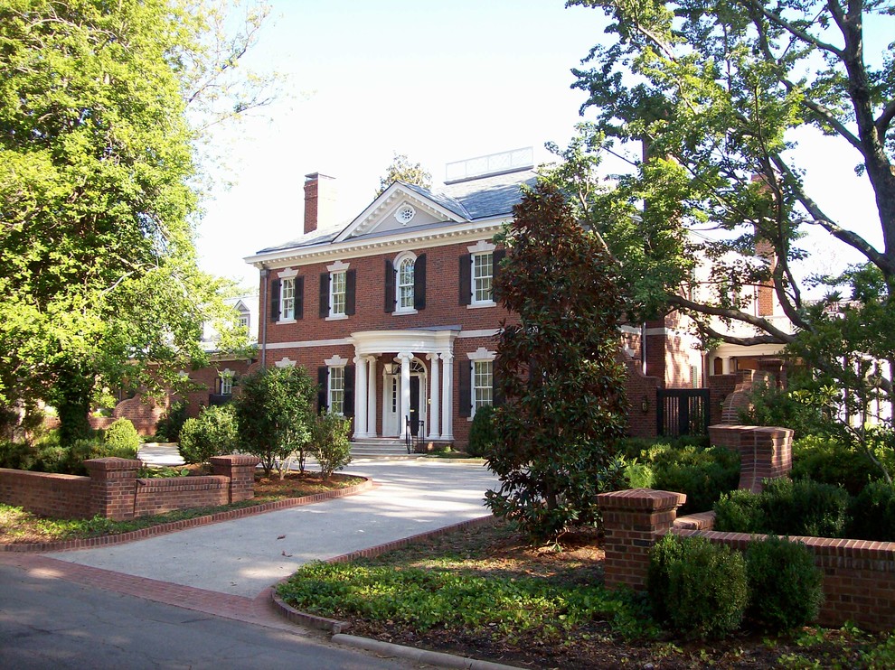 Пример оригинального дизайна: большой, трехэтажный, кирпичный, красный дом в классическом стиле