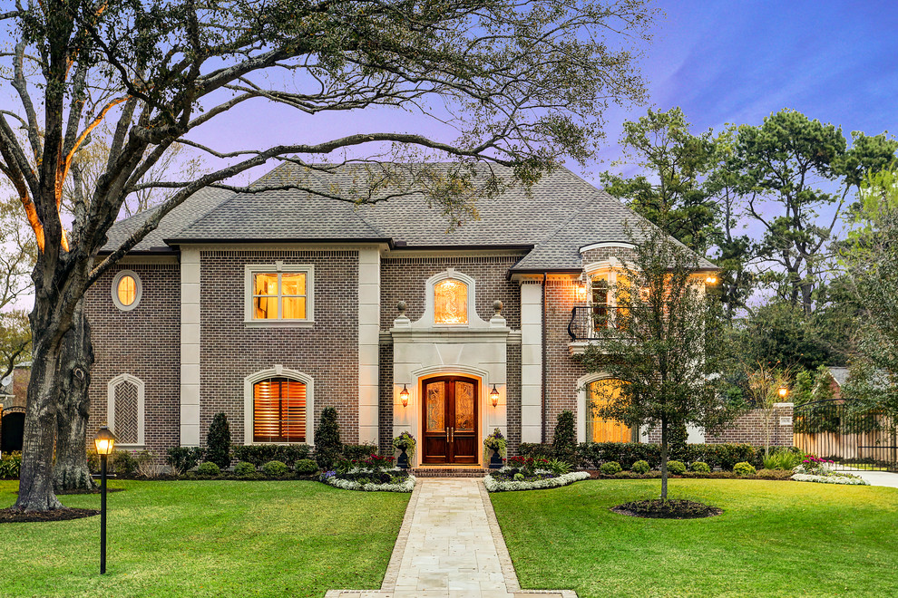 Huge traditional red two-story brick exterior home idea in Houston