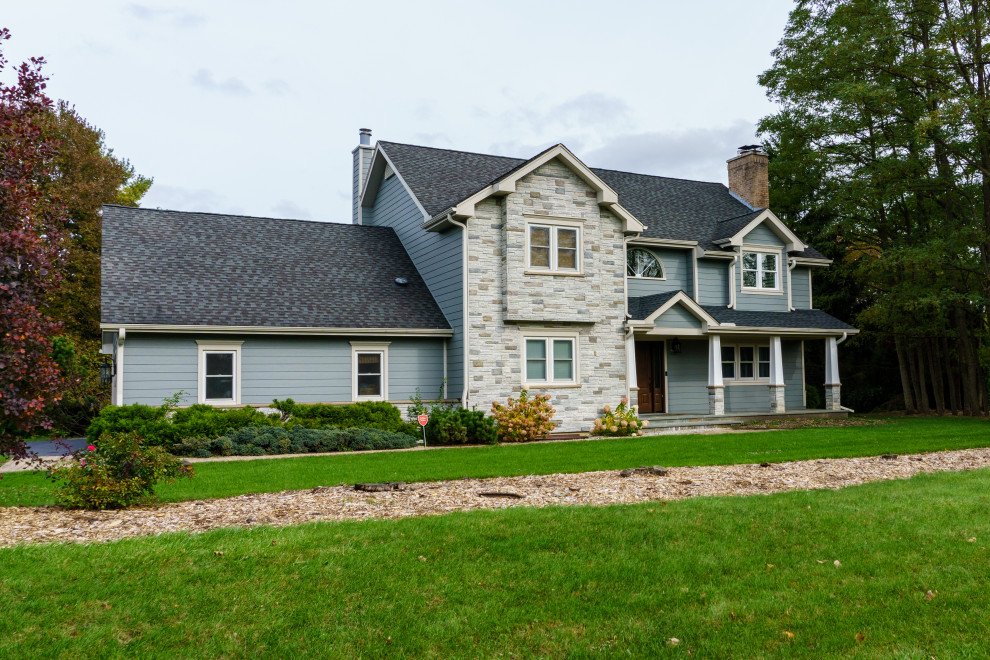 Ejemplo de fachada de casa azul tradicional grande de tres plantas con revestimientos combinados, tejado a dos aguas y tejado de teja de madera