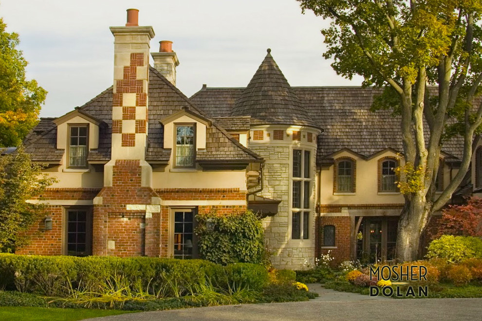 Aménagement d'une grande façade de maison beige classique en brique à deux étages et plus avec un toit à quatre pans.