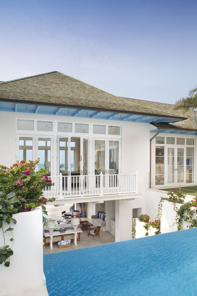 Inspiration for a world-inspired two floor house exterior in Miami with a hip roof.