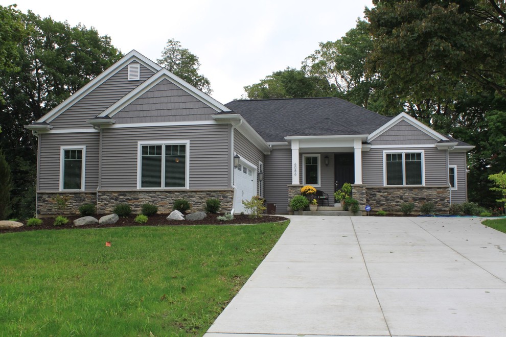 This is an example of a medium sized and gey classic bungalow house exterior in Other with vinyl cladding and a pitched roof.