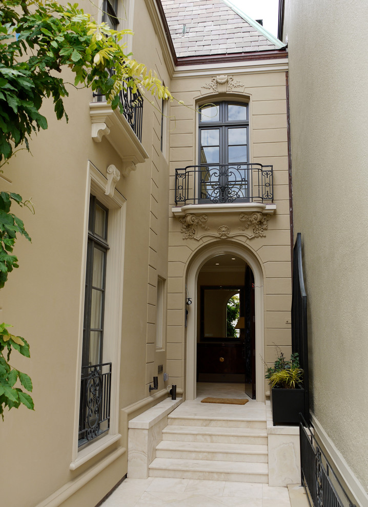 Foto de fachada beige clásica de tres plantas con revestimiento de estuco