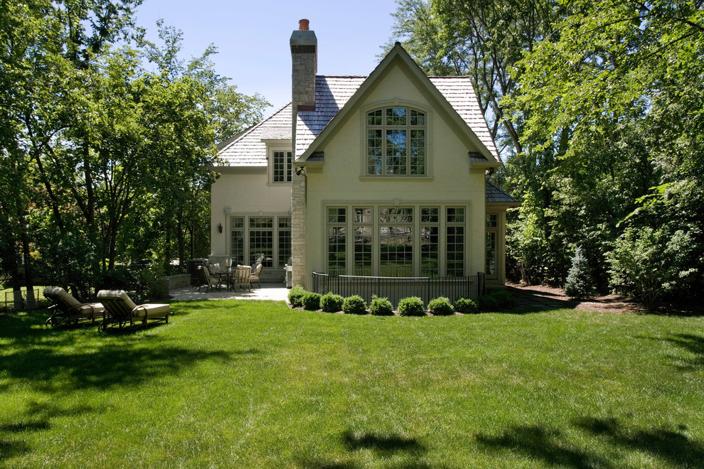 Foto de fachada beige clásica de tamaño medio de dos plantas con revestimiento de estuco y tejado a dos aguas