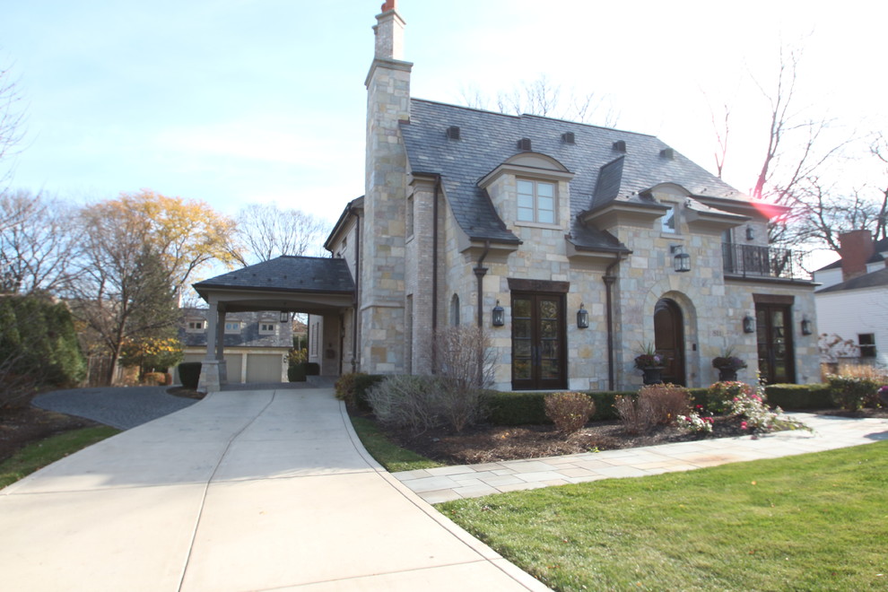 Inspiration for a mid-sized timeless beige two-story stone house exterior remodel in Chicago with a hip roof and a shingle roof