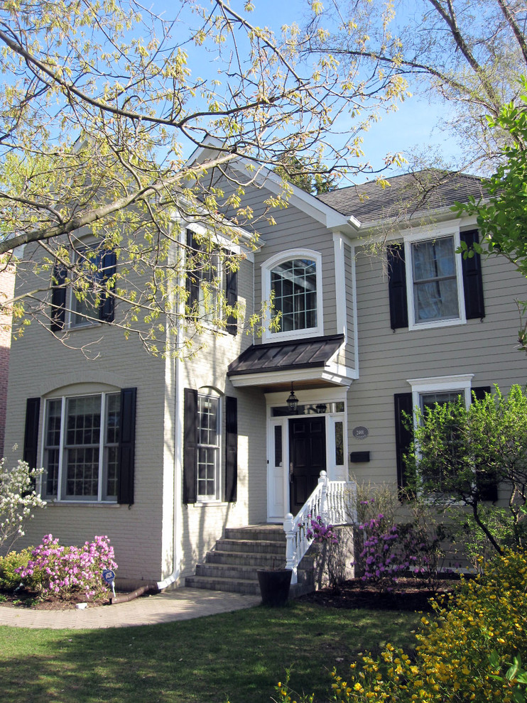 Exemple d'une façade de maison beige chic en panneau de béton fibré de taille moyenne et à un étage avec un toit à deux pans et un toit mixte.