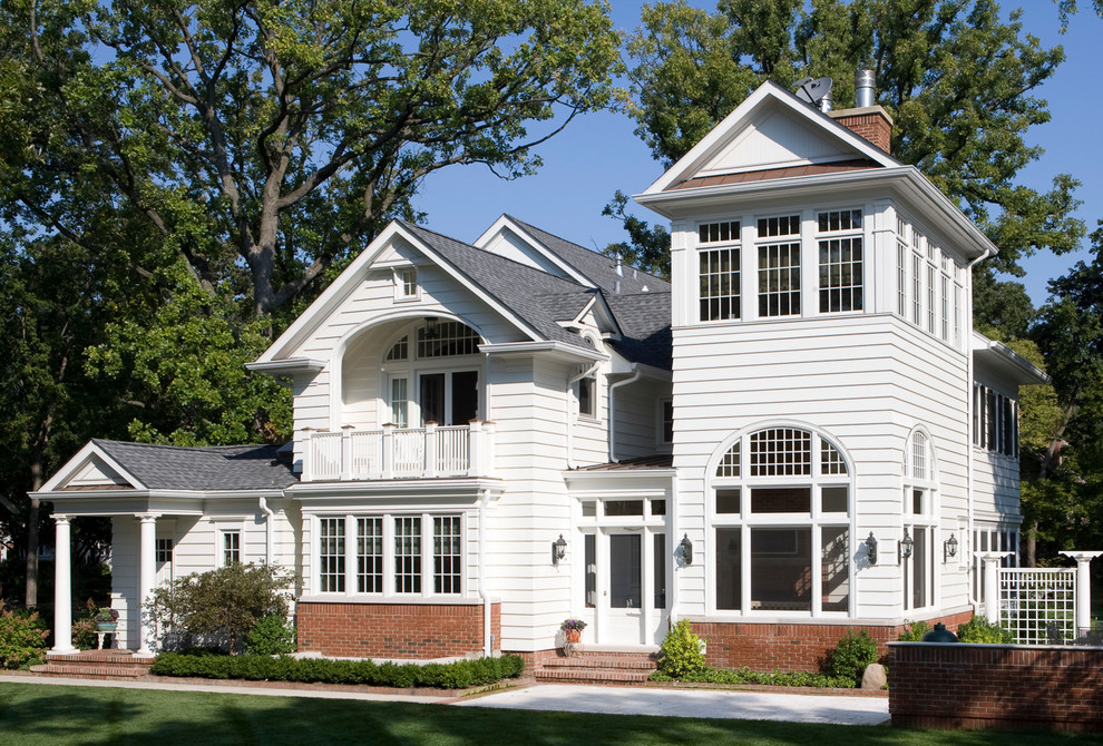 Exemple d'une façade de maison blanche chic en bois à deux étages et plus avec un toit à deux pans.