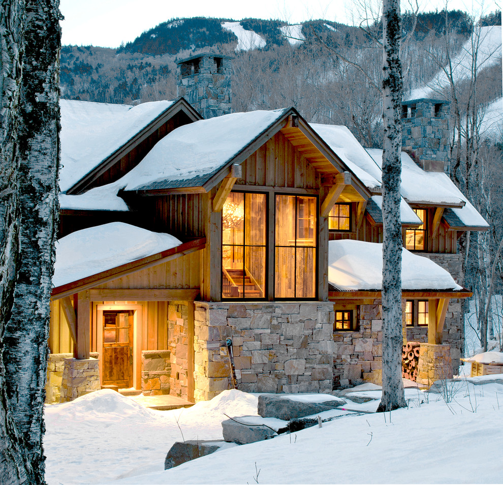 Cette image montre une façade de maison marron chalet à un étage avec un revêtement mixte et un toit à deux pans.