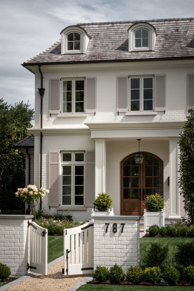 Diseño de fachada de casa blanca clásica renovada grande de tres plantas con revestimiento de ladrillo, tejado a cuatro aguas y tejado de teja de madera