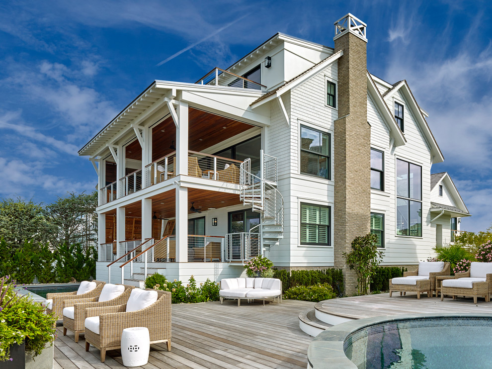 Large beach style white three-story wood exterior home photo in Philadelphia with a mixed material roof