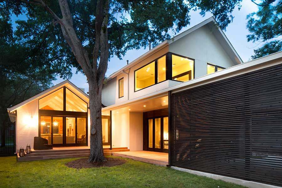 This is an example of a medium sized and white contemporary two floor house exterior in Austin with a pitched roof.