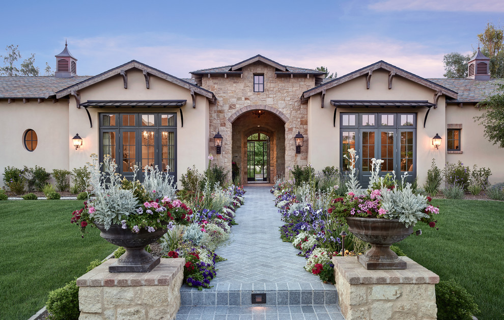 Inspiration pour une grande façade de maison beige méditerranéenne de plain-pied avec un revêtement mixte, un toit à deux pans et un toit en shingle.