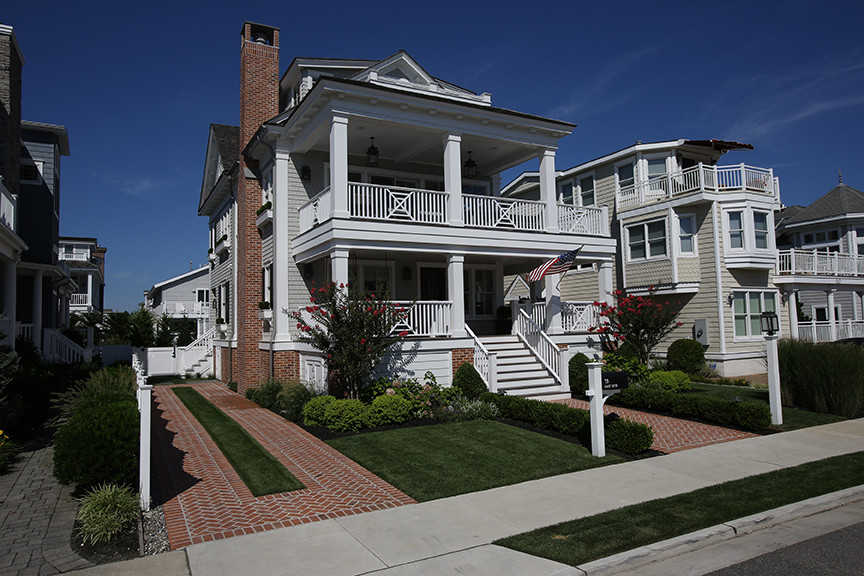 Diseño de fachada beige de estilo americano de tamaño medio de dos plantas con revestimiento de madera y tejado a dos aguas