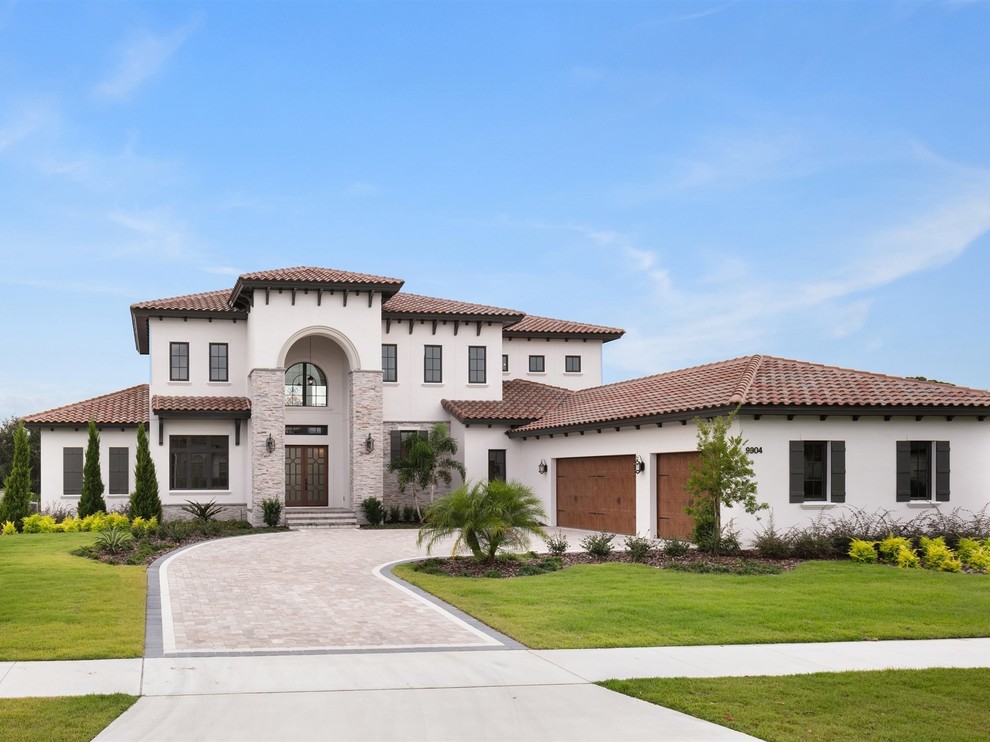 Large transitional white two-story stucco house exterior photo in Orlando with a hip roof and a tile roof