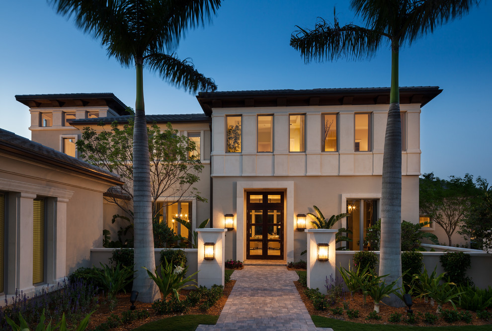 Inspiration for a transitional beige two-story exterior home remodel in Miami