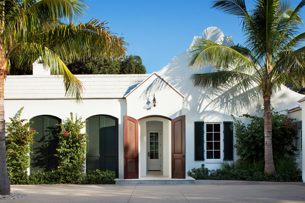 Mittelgroßes, Einstöckiges Klassisches Einfamilienhaus mit weißer Fassadenfarbe, Putzfassade und weißem Dach in Miami