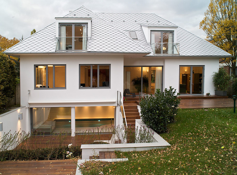 Idées déco pour une façade de maison blanche campagne à un étage avec un toit à croupette.