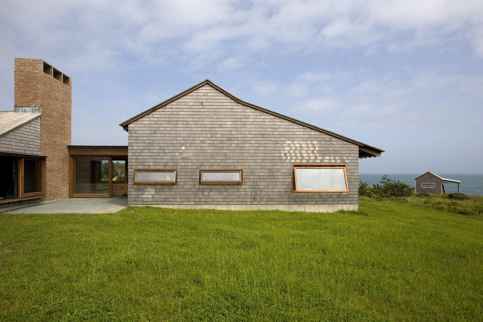 Cette photo montre une façade de maison chic en bois de plain-pied avec un toit à deux pans.