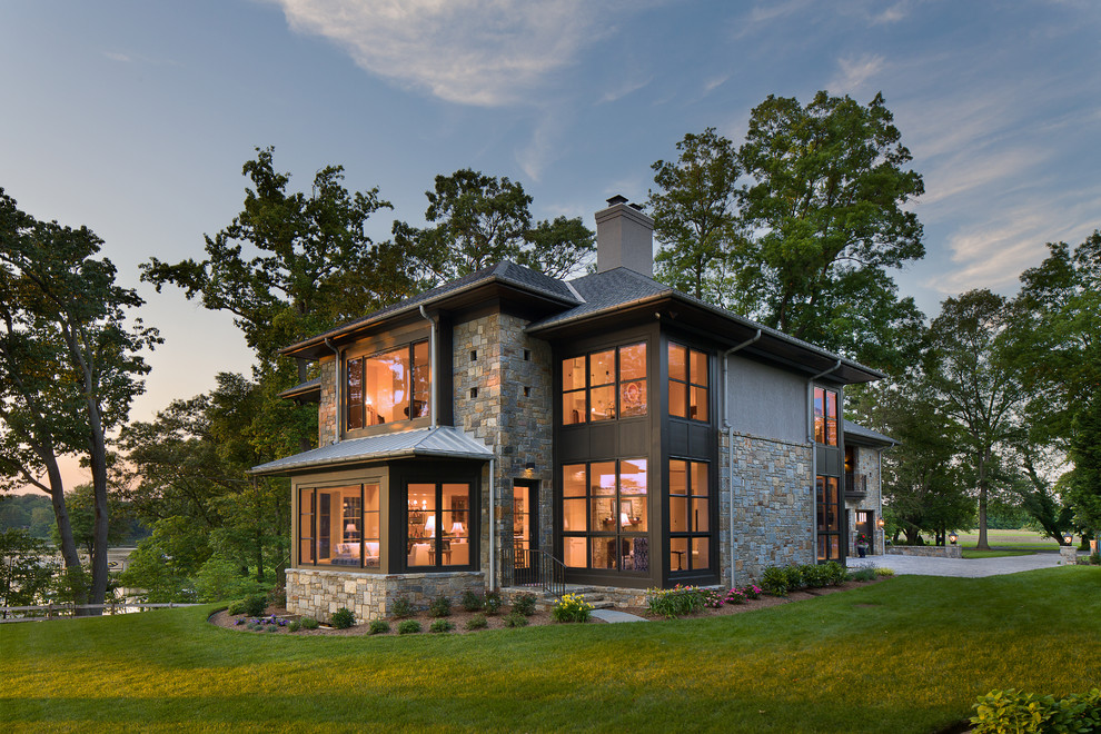 Inspiration pour une façade de maison grise traditionnelle en pierre à un étage avec un toit à quatre pans et un toit mixte.
