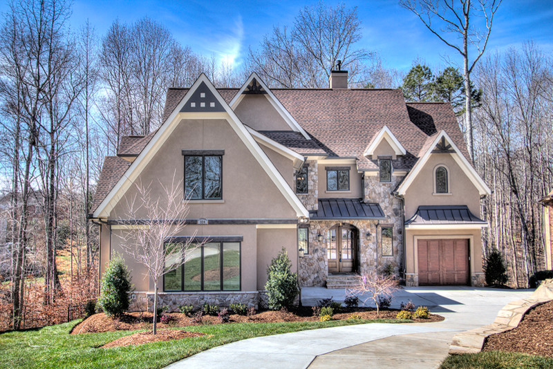 Large transitional brown three-story stucco gable roof photo in Charlotte