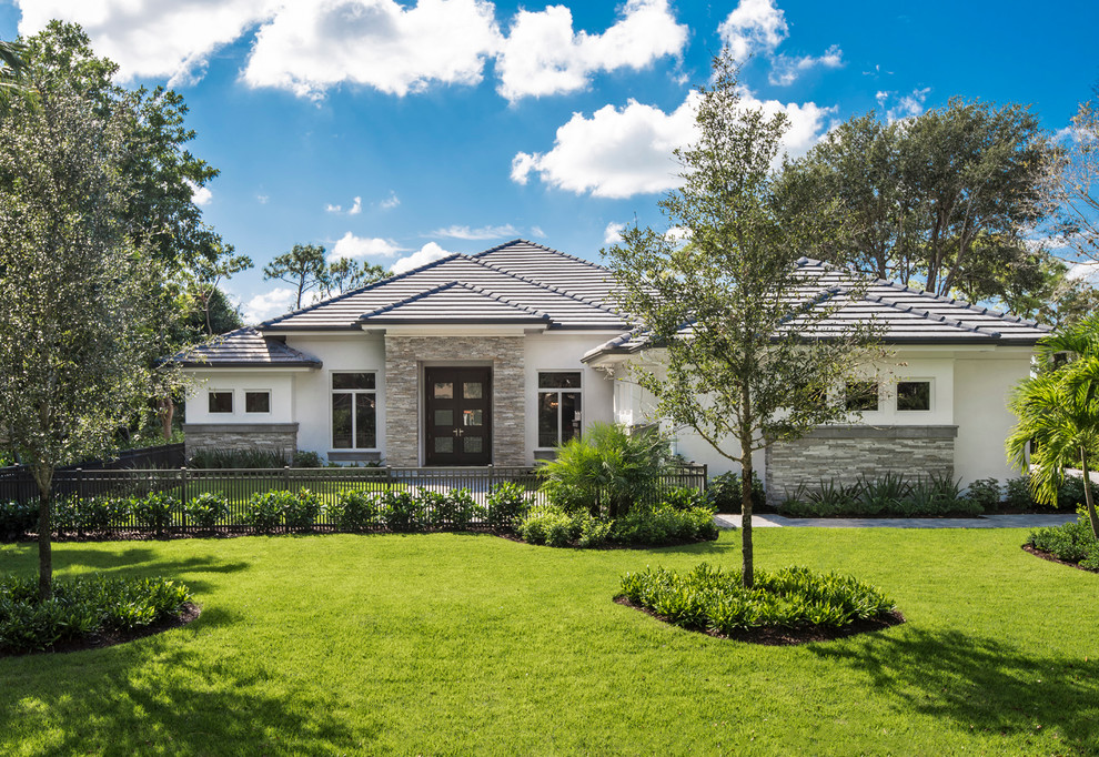 Mittelgroßes, Einstöckiges Klassisches Einfamilienhaus mit Putzfassade, grauer Fassadenfarbe und Walmdach in Miami
