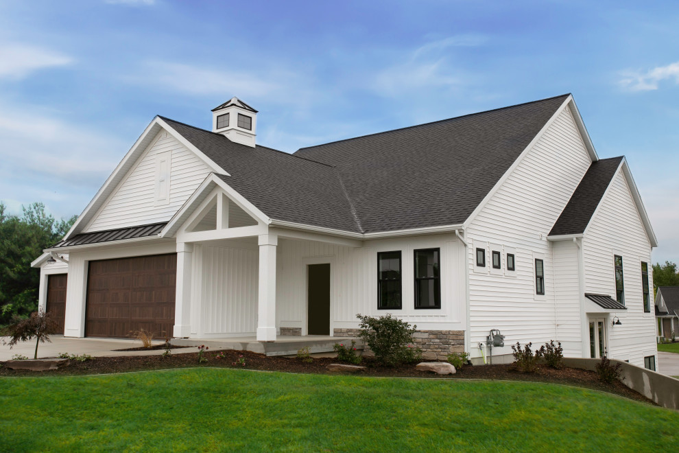 Diseño de fachada de piso blanca de estilo de casa de campo de una planta con revestimiento de vinilo, tejado a dos aguas y tejado de varios materiales
