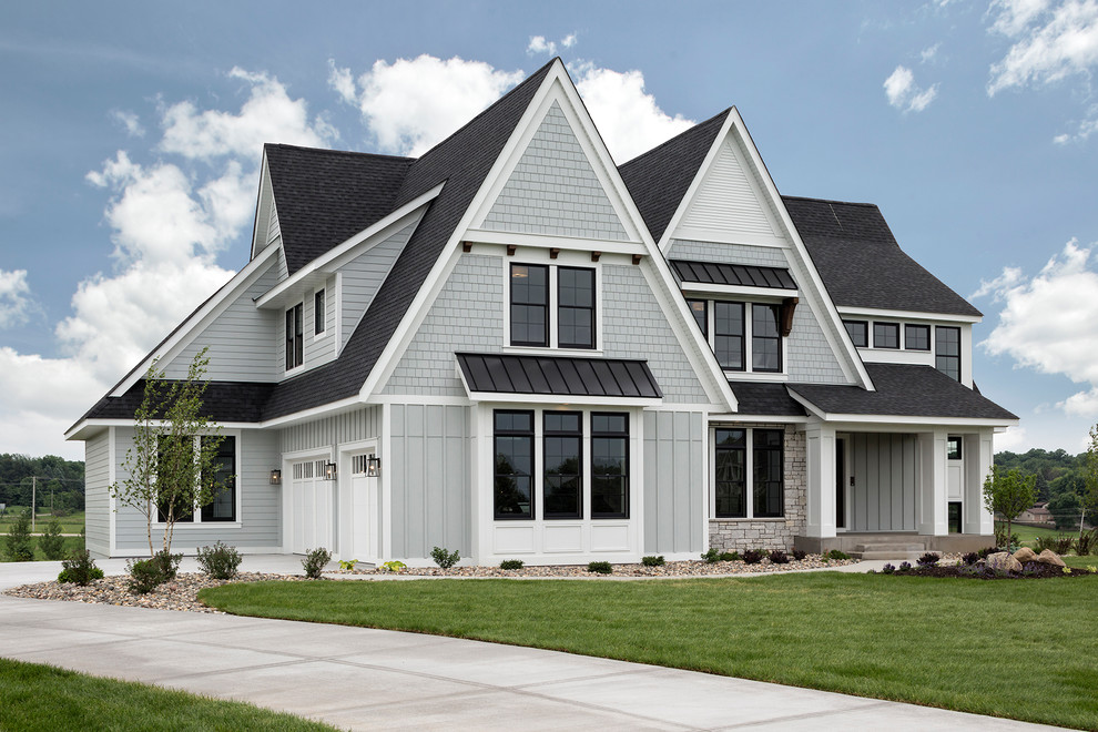 Exemple d'une grande façade de maison grise chic en panneau de béton fibré à un étage avec un toit à deux pans et un toit mixte.