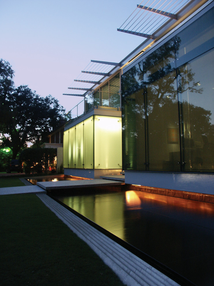 Immagine della facciata di una casa contemporanea con rivestimento in vetro