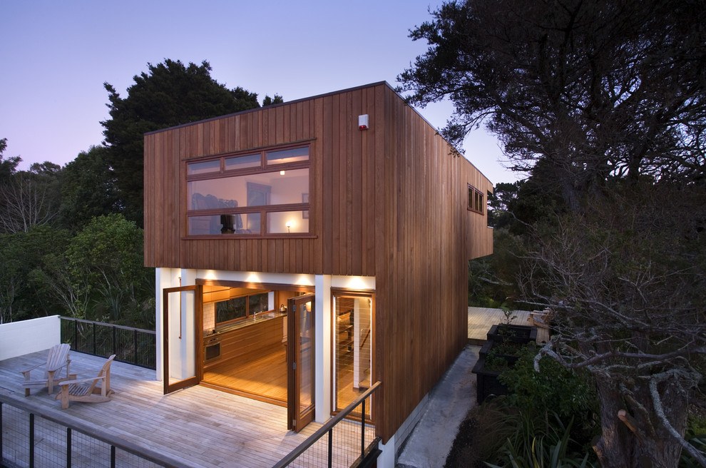 Design ideas for a contemporary two floor house exterior in Auckland with wood cladding and a flat roof.